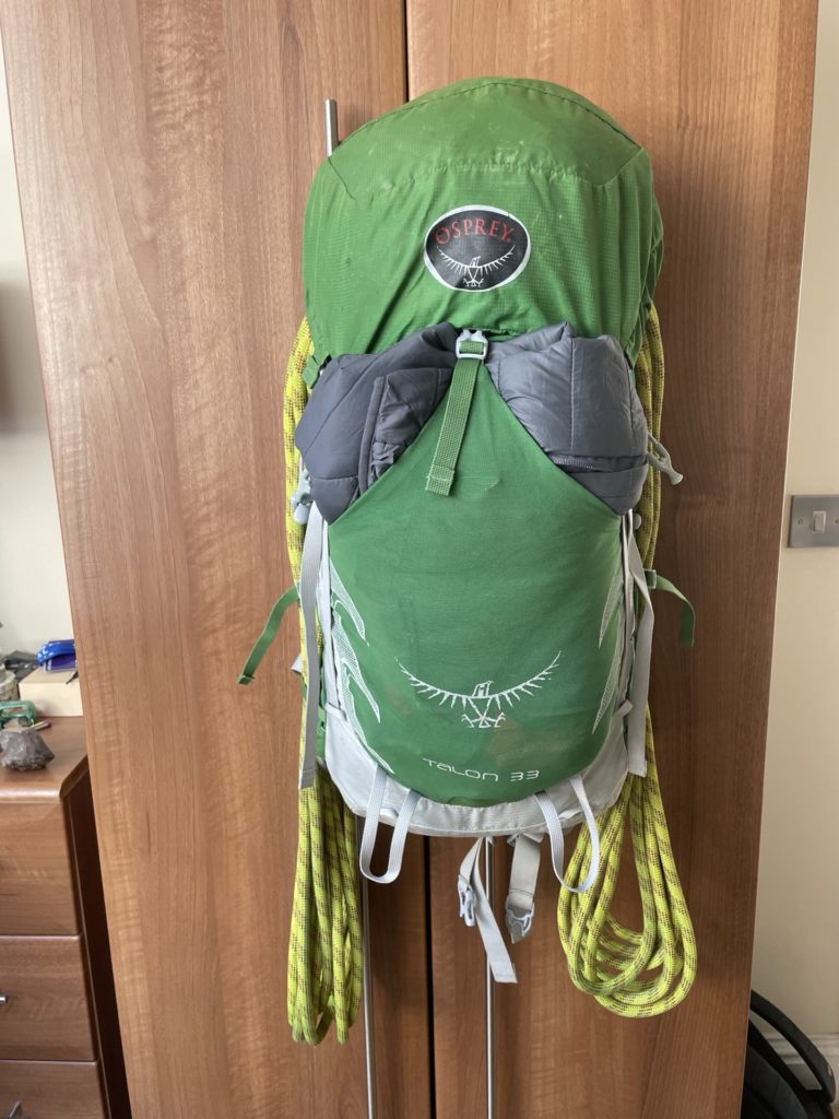 A rope packed into the Osprey Talon 33, under the brain and secured with the cinch straps.