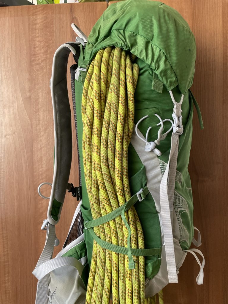 Side view of a rope packed into the Osprey Talon 33, under the brain and secured with the cinch straps.