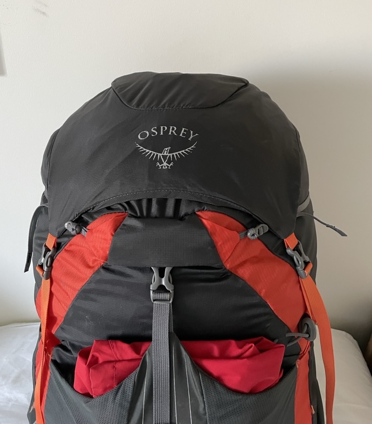 Osprey Exos 58 Blaze (black & orange) with 'brain' removed and a coat in the mesh pouch